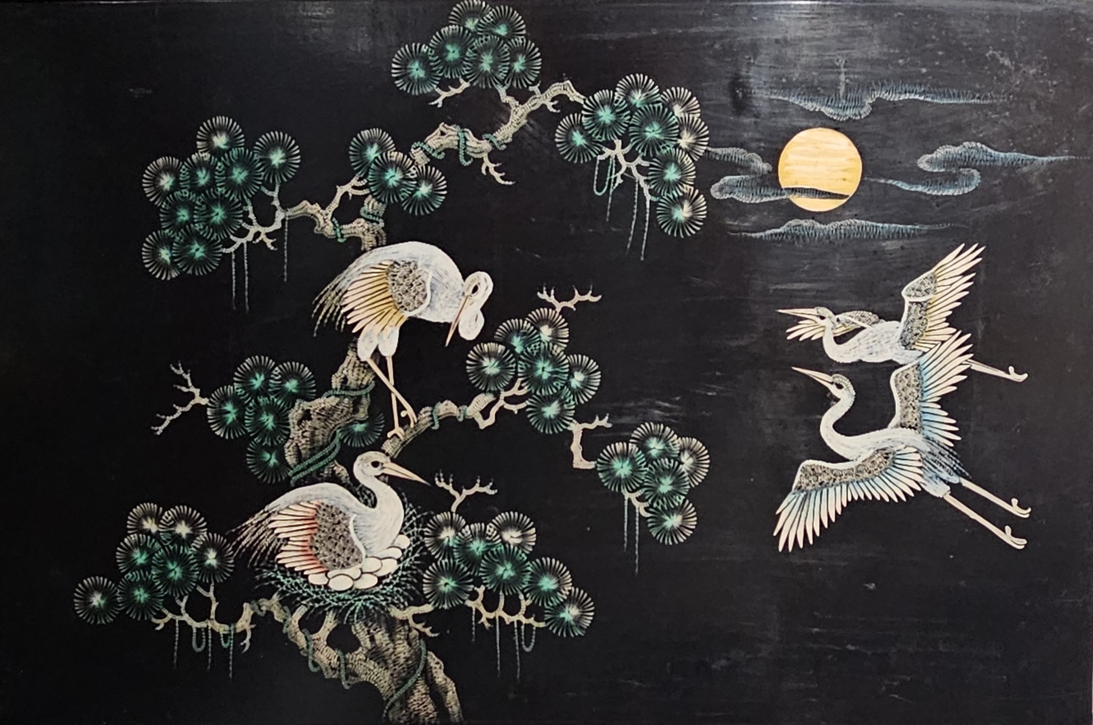 A serene depiction of cranes perched on a stylized tree against a dark background, with two cranes flying towards a golden sun partially hidden by clouds.