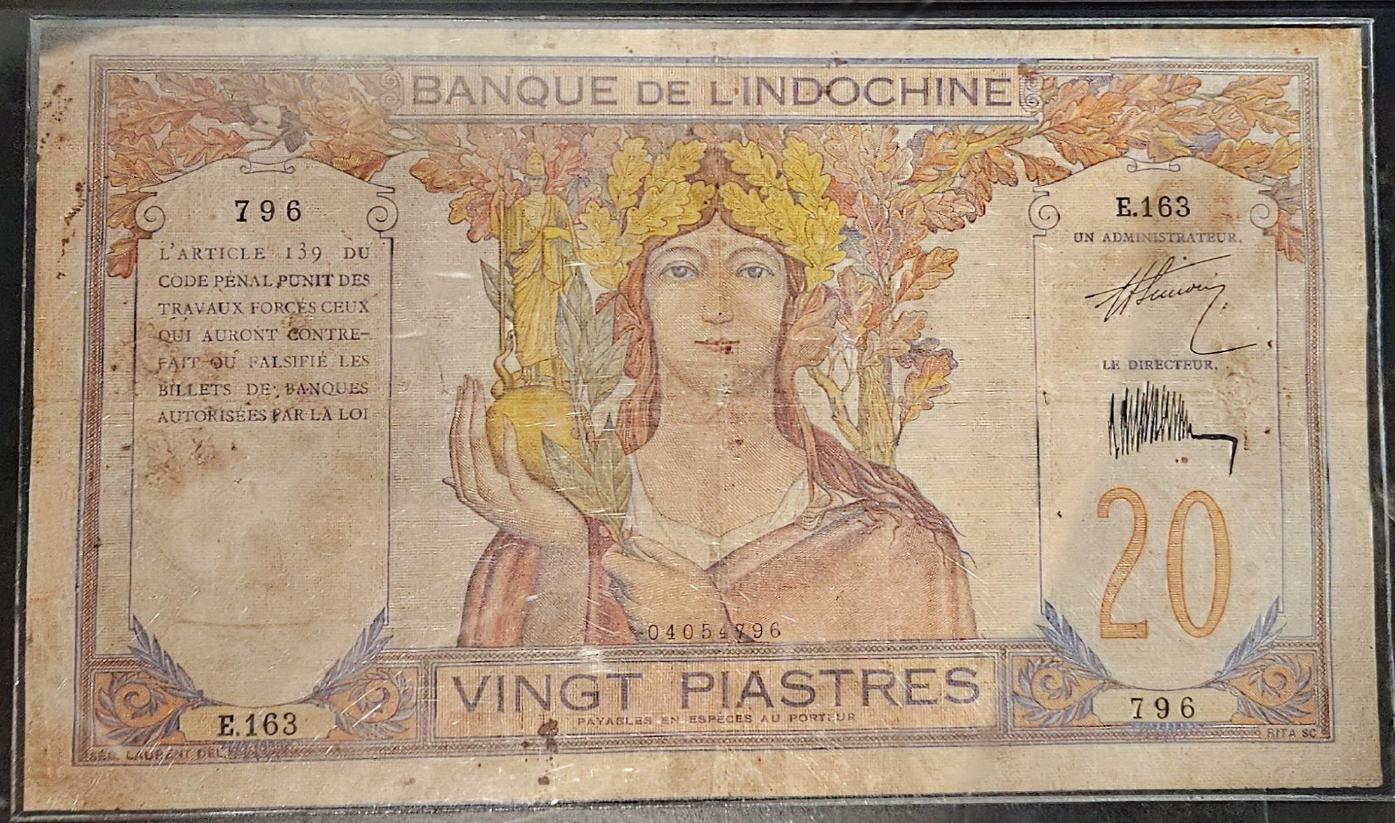 A vintage banknote from Banque de l'Indochine, denomination of 20 piastres, featuring a woman adorned with a floral crown holding a fruit in one hand.
