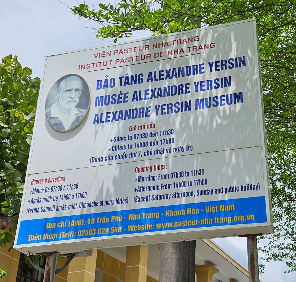 Sign for the Alexandre Yersin Museum in Nha Trang, Vietnam, featuring opening hours and contact information.
