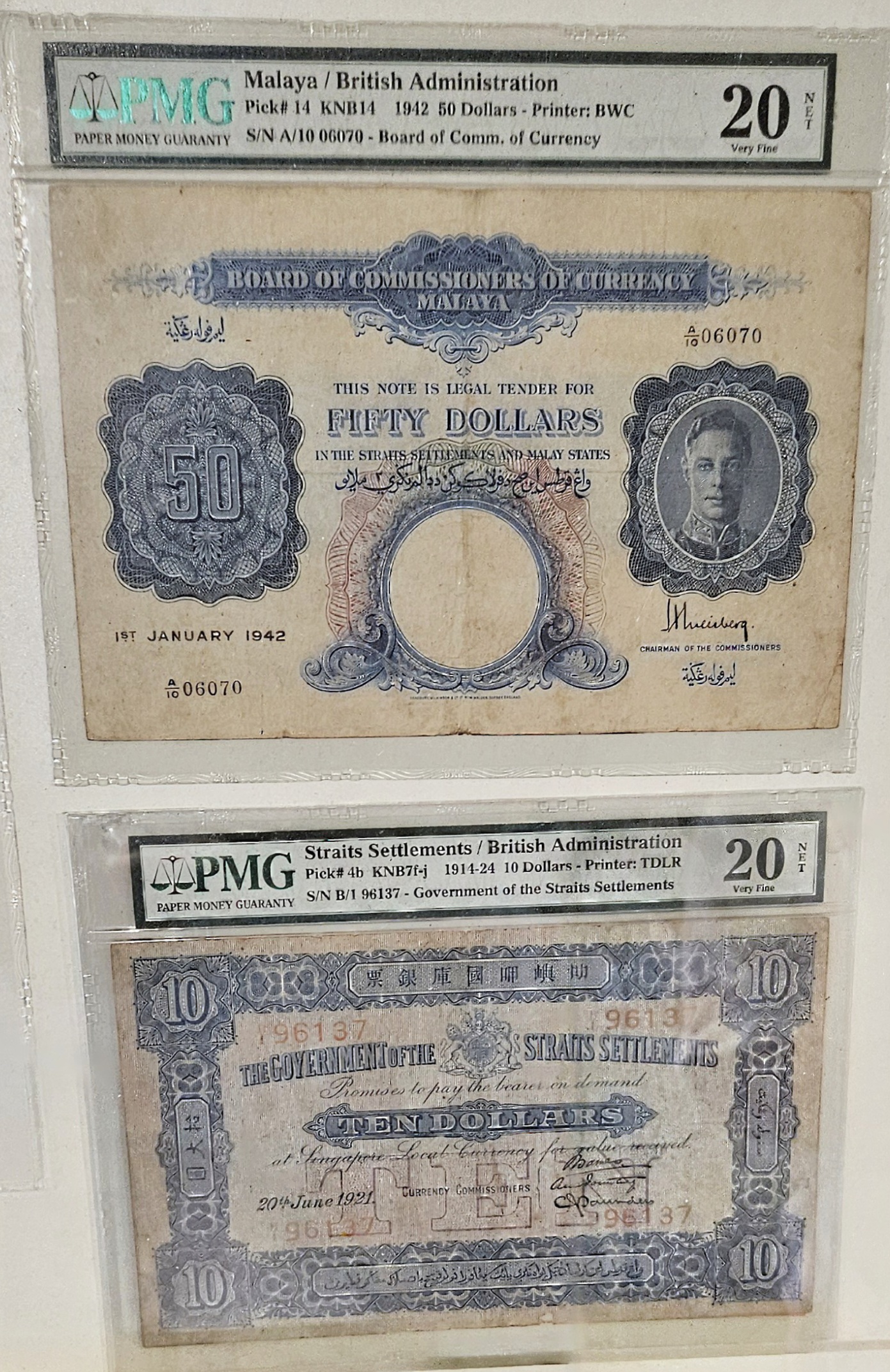 Collection of two banknotes: a 1942 fifty dollar note from Malaya and a 1914 ten dollar note from the Straits Settlements, both encapsulated and graded by PMG.