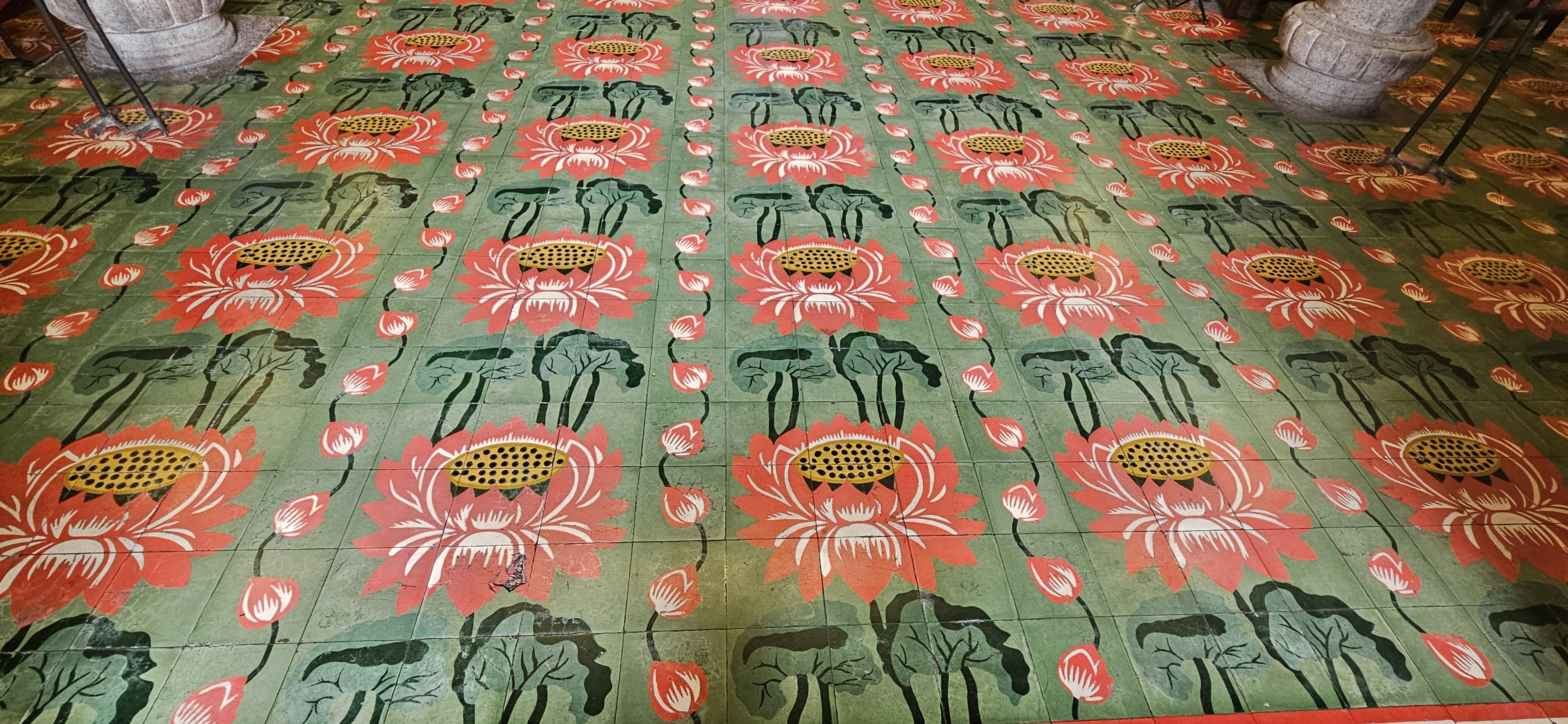 Decorative tiled floor featuring colorful lotus designs in shades of pink and green.